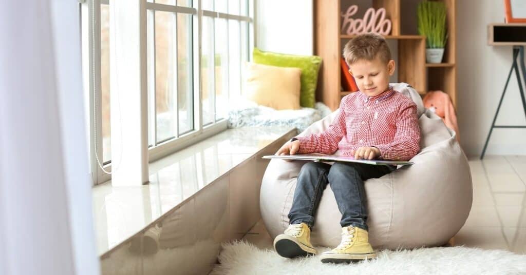 boy reading a book in a bean bag